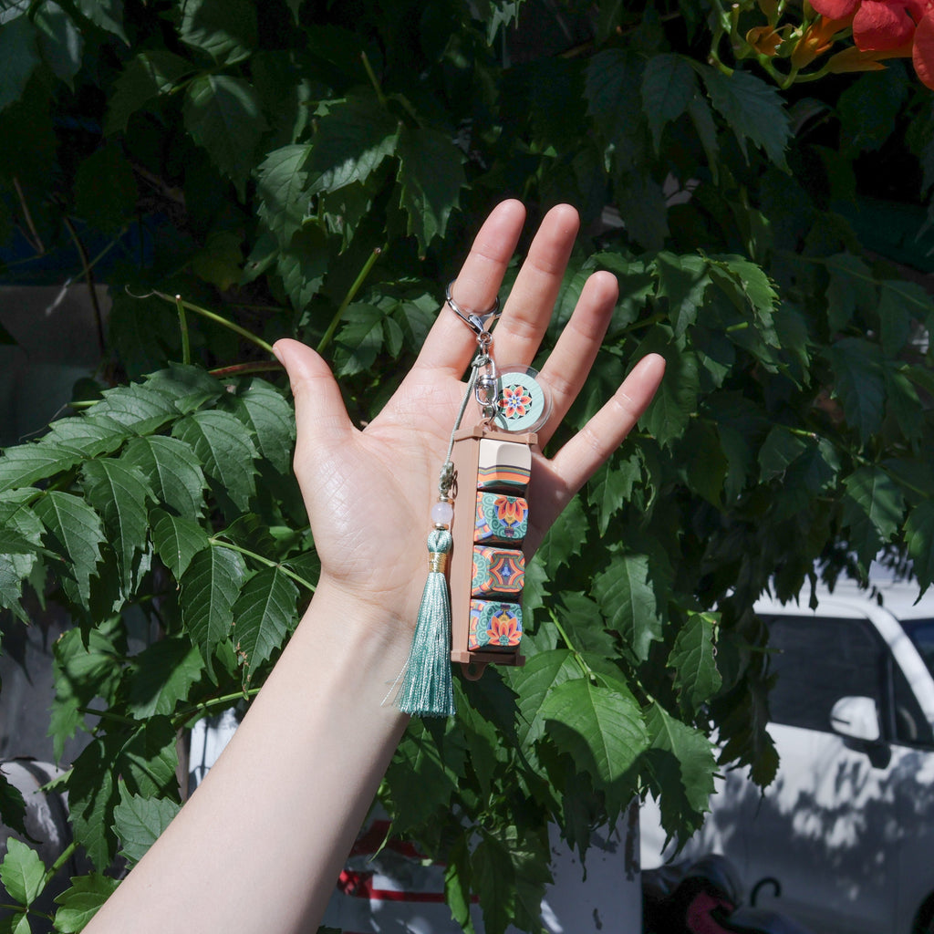 Hand holding a white dancheong keycap keychain