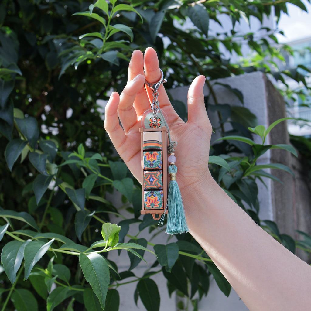 Hand holding a white dancheong keycap keychain